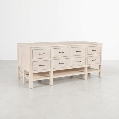 Light wood dresser with eight drawers and a lower shelf.