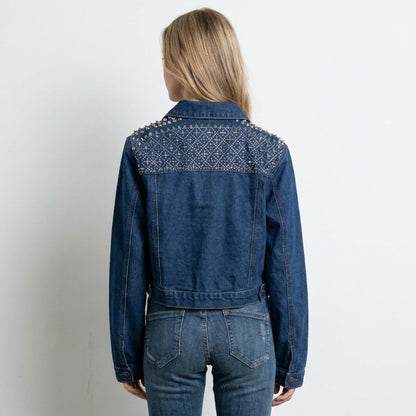 Person in studded denim jacket, seen from the back.