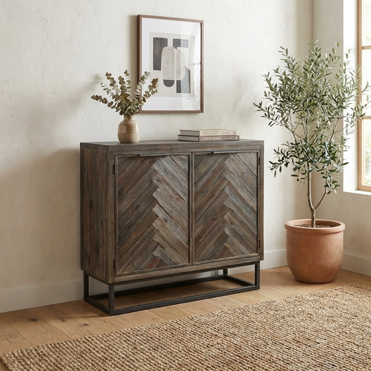 Wooden cabinet with chevron pattern, potted plant, artwork, and books on top.