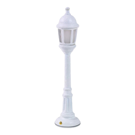 White decorative mini lamp post on a plain background.
