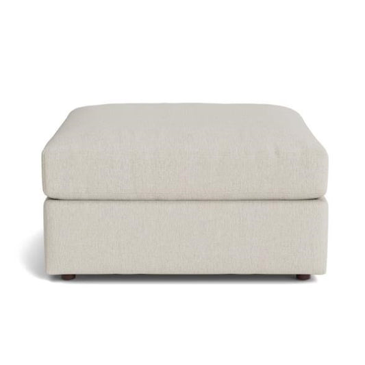 Cream-colored ottoman with a cushioned top and small feet.