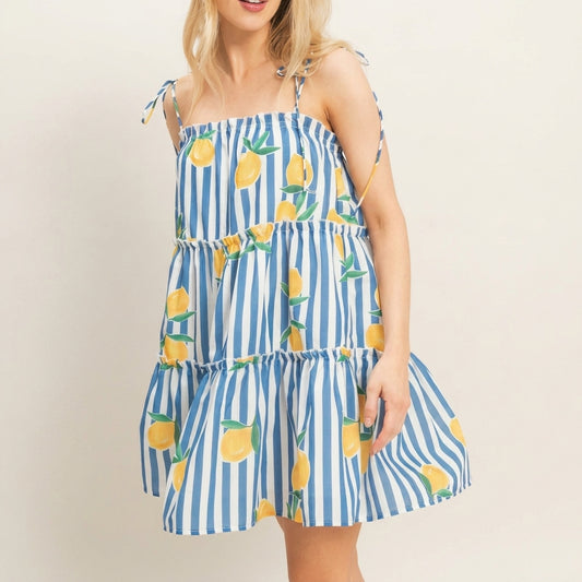 Woman in a blue-striped lemon print dress with shoulder ties.
