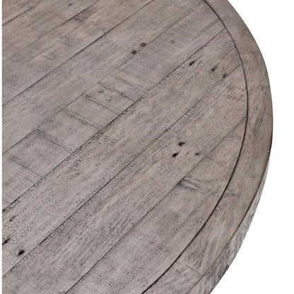 Close-up of a round wooden table with a gray, rustic finish.