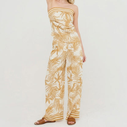 Model in leaf-patterned, strapless jumpsuit with sandals.
