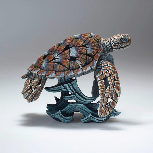Colorful mosaic sea turtle sculpture on a wave.