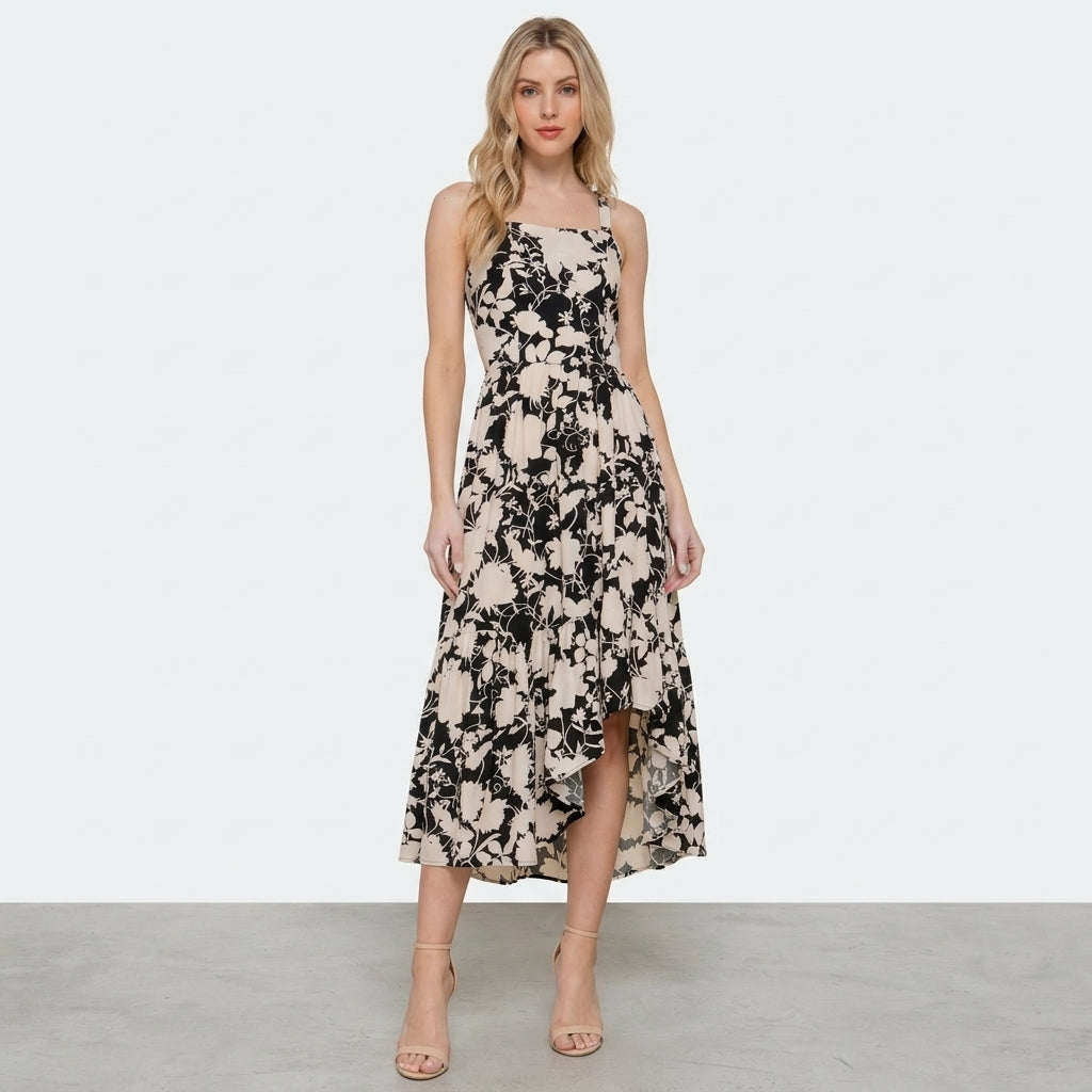 Woman in a floral dress and heels against a plain background.