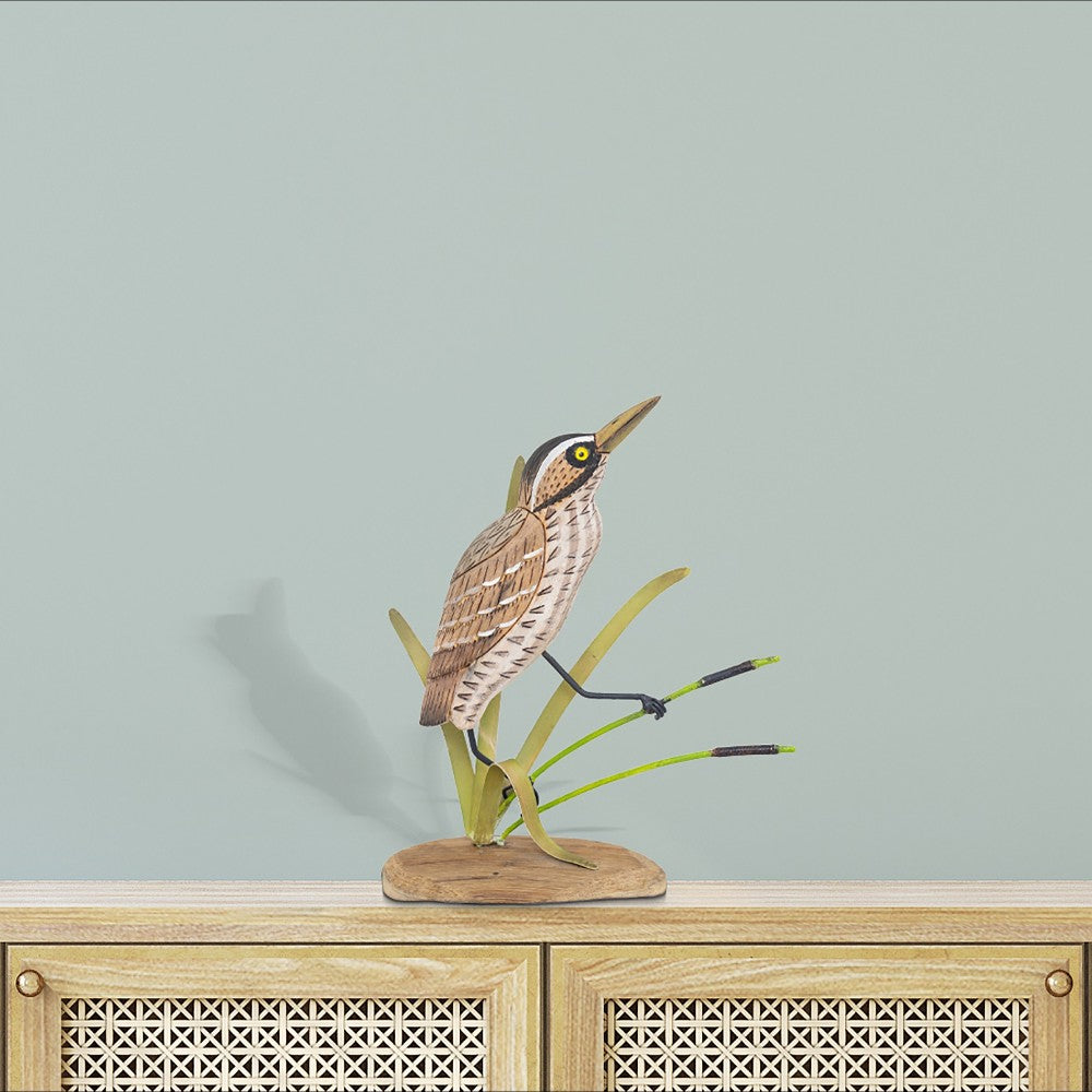 Wooden bird sculpture on a rattan cabinet.
