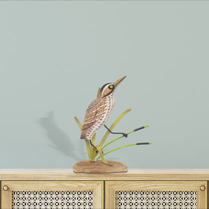 Wooden bird sculpture on a rattan cabinet.