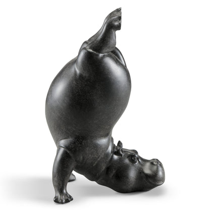 Black hippo sculpture doing a headstand.