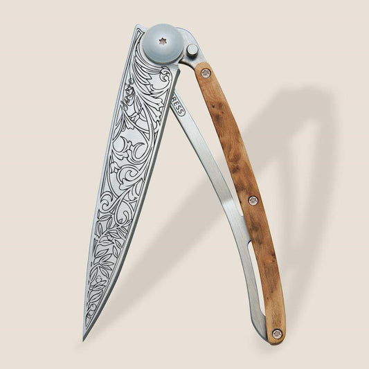 Ornate folding knife with engraved blade and wooden handle.