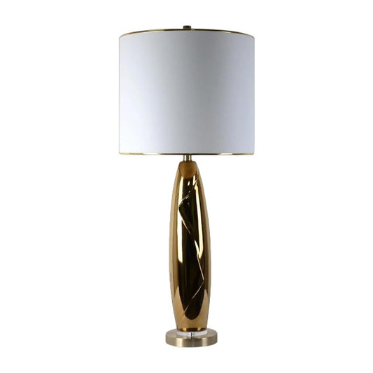 Modern lamp with a sleek gold base and white shade.