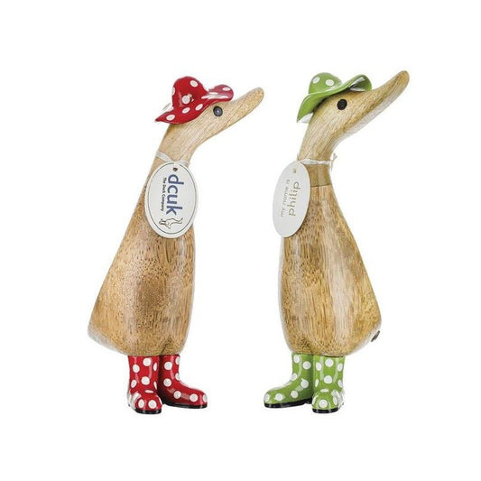 Two wooden ducks wearing polka dot hats and boots.