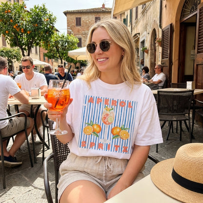 Woman enjoying a drink at an outdoor café on a sunny day.