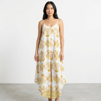 Woman in a floral dress standing against a plain white background.