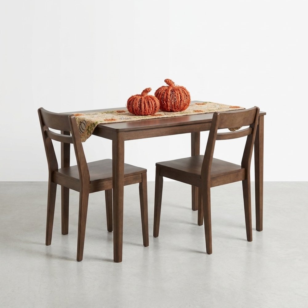 Wooden table set with pumpkin decor and a festive table runner.
