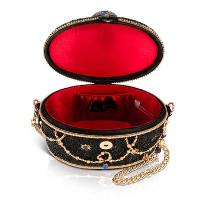 Elegant black clutch with red interior and gold chain.