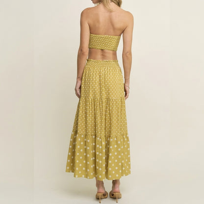 Woman in a yellow polka dot two-piece outfit, viewed from the back.