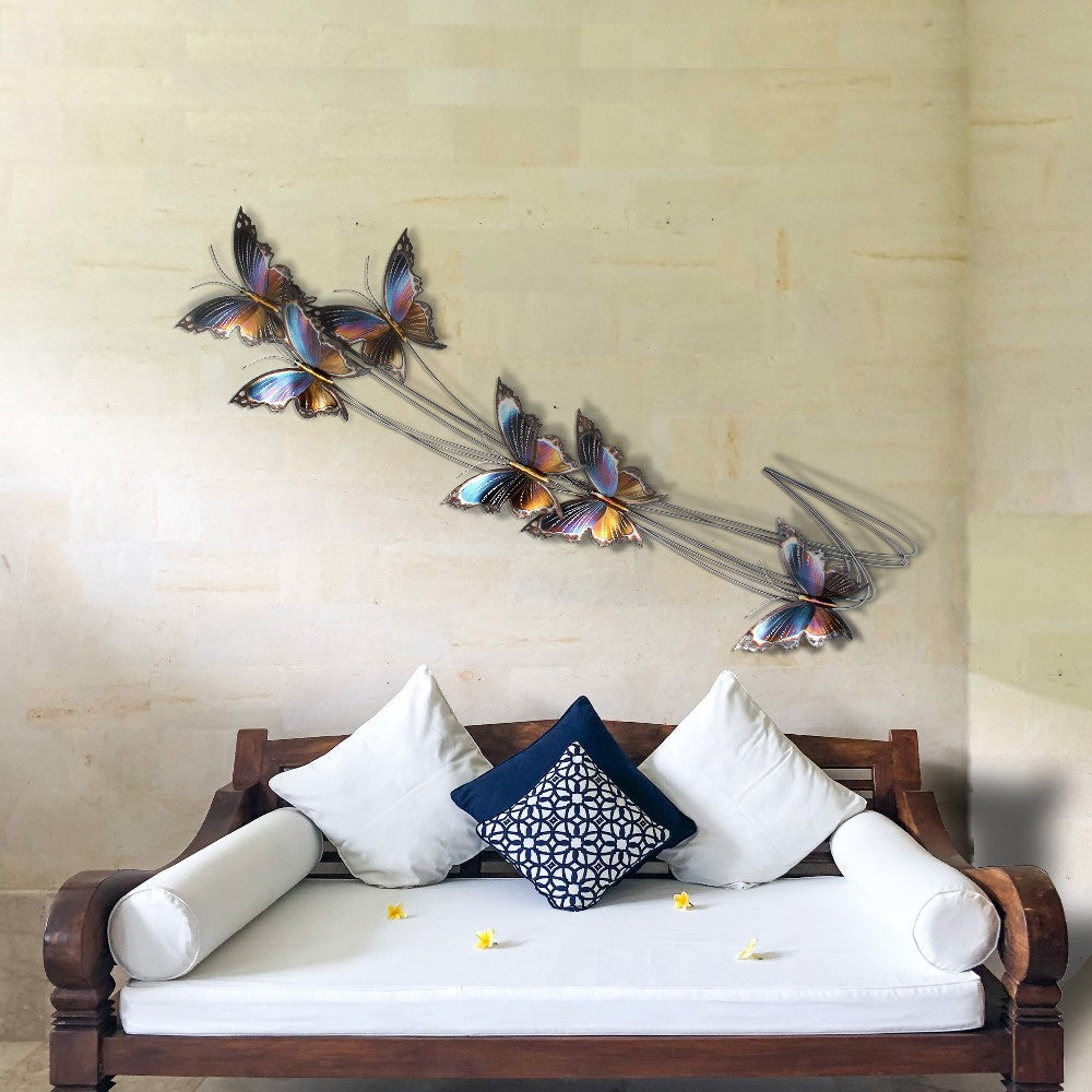 Wooden sofa with pillows, butterfly wall art above.