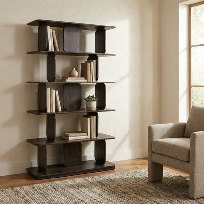 Modern bookshelf with books and decor next to a cozy armchair by a window.