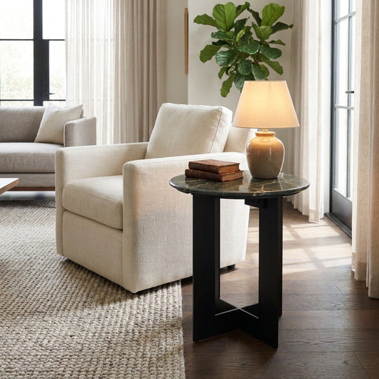 Round green marble side table with intersecting legs.
