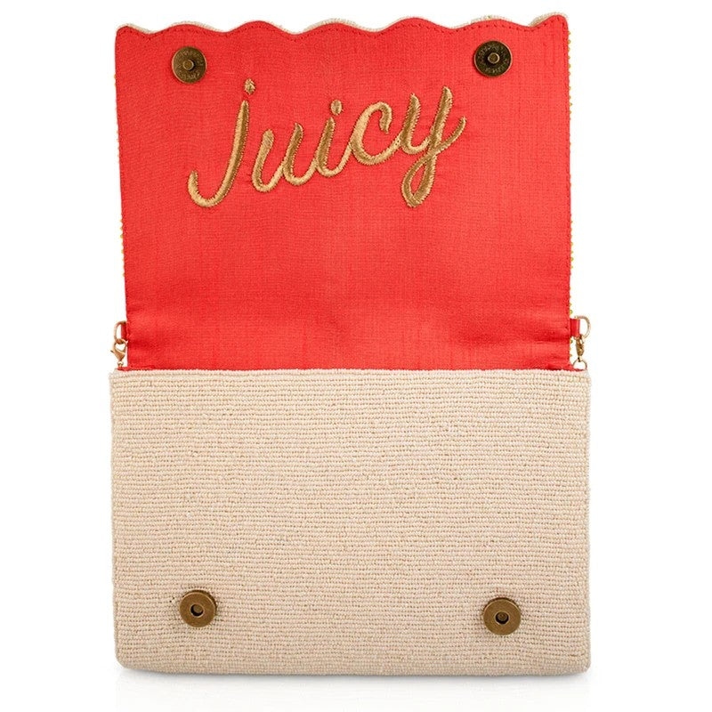 Open beige clutch with "Juicy" inside the red flap.
