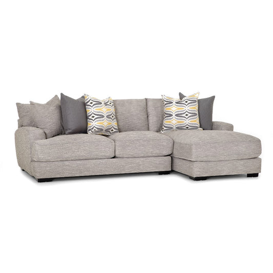 Gray sectional sofa with patterned and solid pillows.