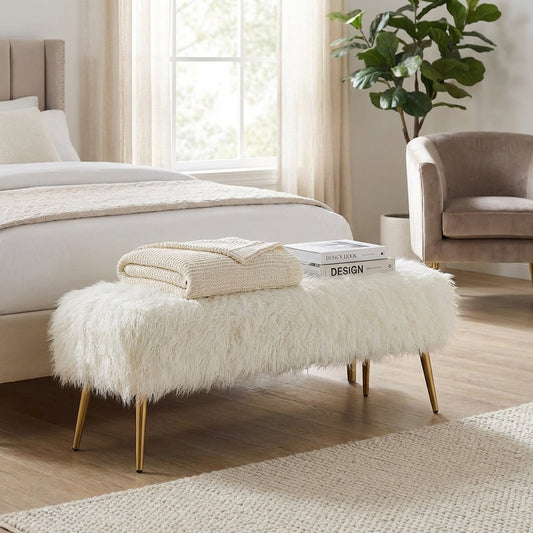 Fuzzy white bench with gold legs.
