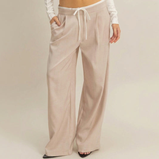 Wide-legged beige pants with white drawstring.