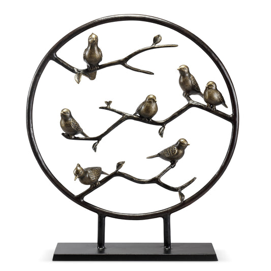 Metal sculpture of birds on branches within a circular frame.