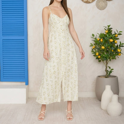 Woman in floral dress near lemon tree and blue shutters.