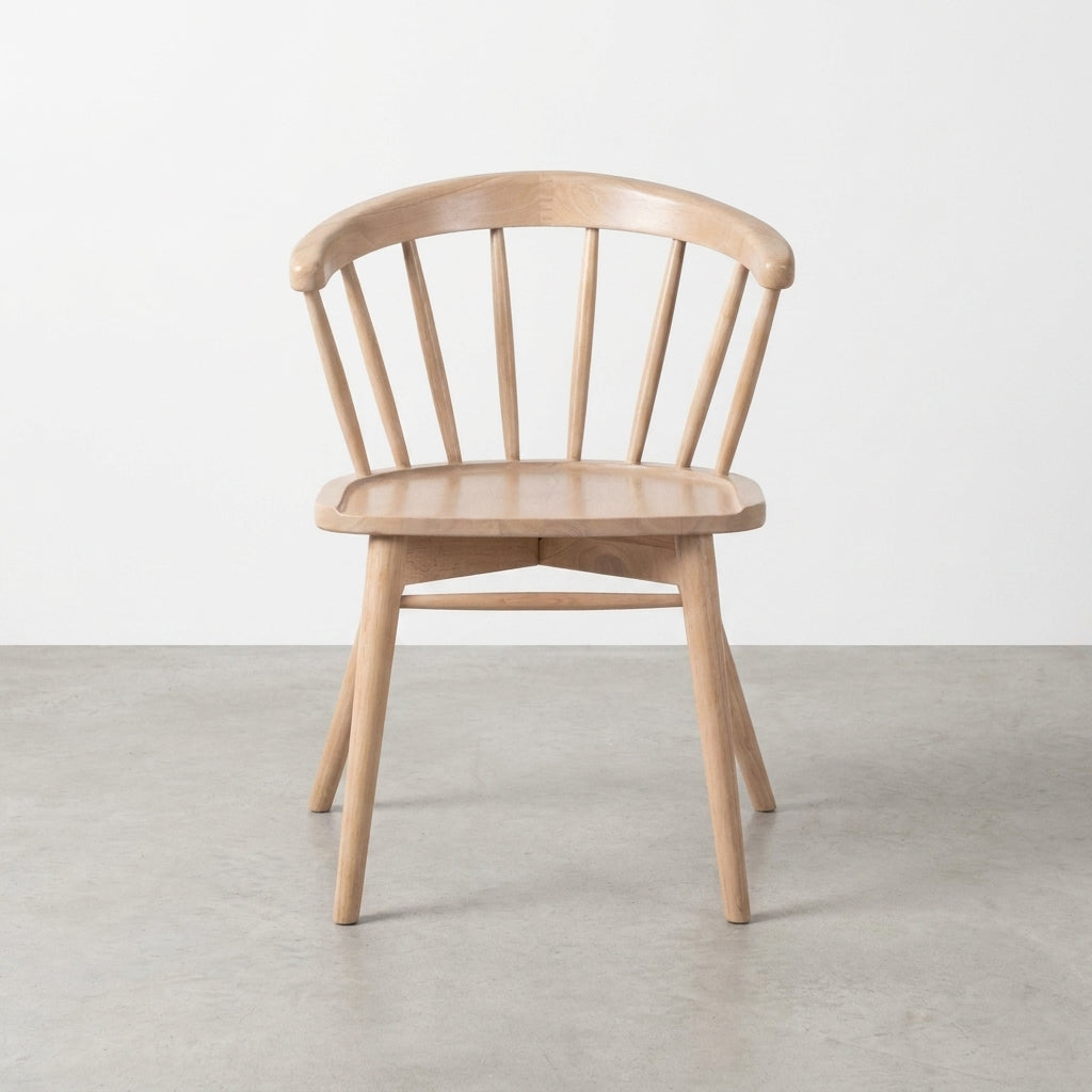 Simple wooden chair with a curved back and spindles, on a light gray floor.