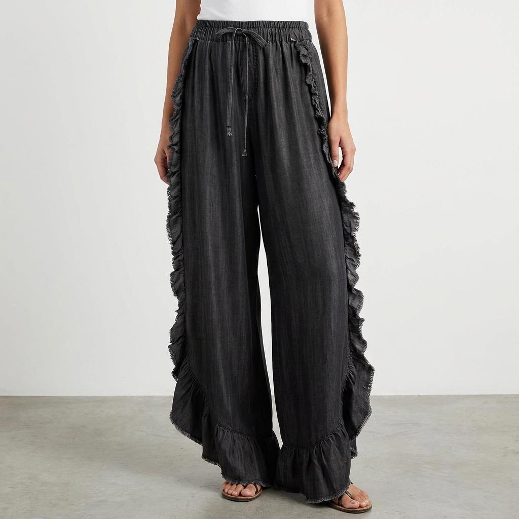 Wide-leg ruffled black pants with a white top.