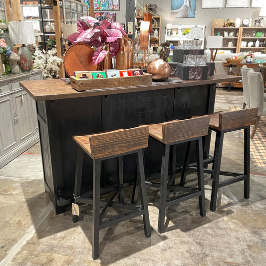 Rustic bar setup with stools and decor in a furniture store.