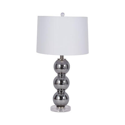 Modern lamp with a white shade and stacked metallic spheres as base.
