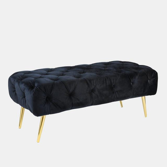 A black tufted velvet bench with elegant gold legs.