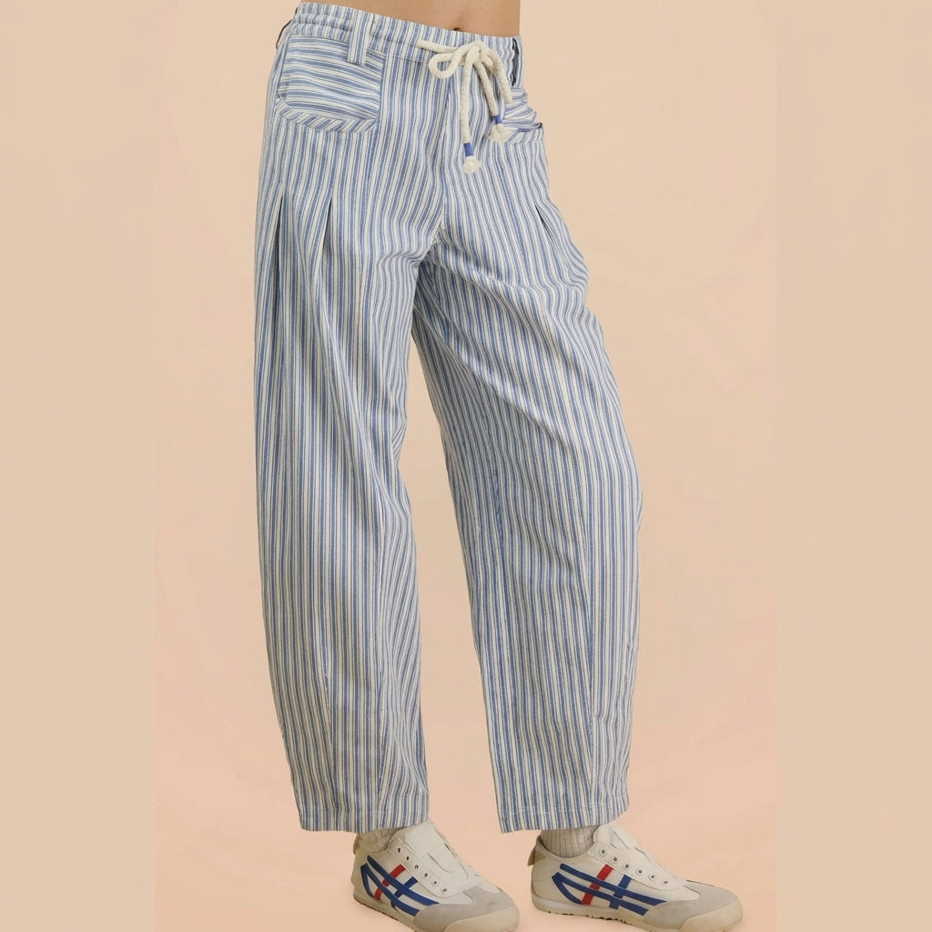 Striped blue pants with drawstring, paired with white sneakers.