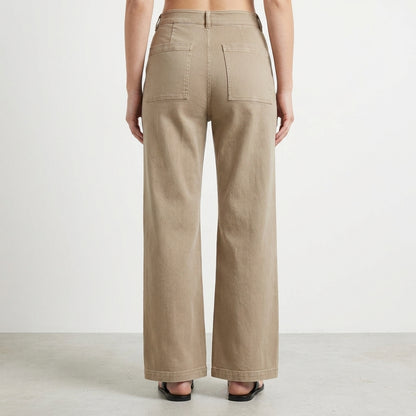 Person in high-waisted beige pants, seen from the back.