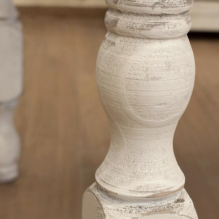 Close-up of a white, textured wooden table leg.