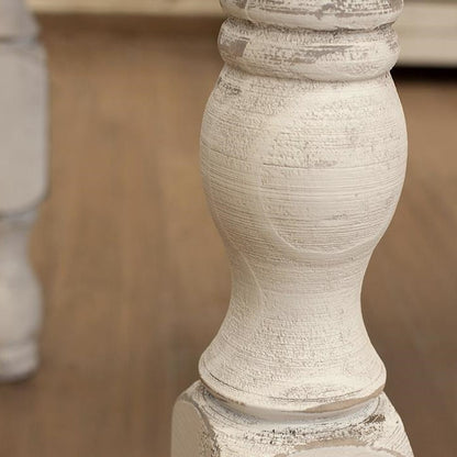 Close-up of a white, textured wooden table leg.