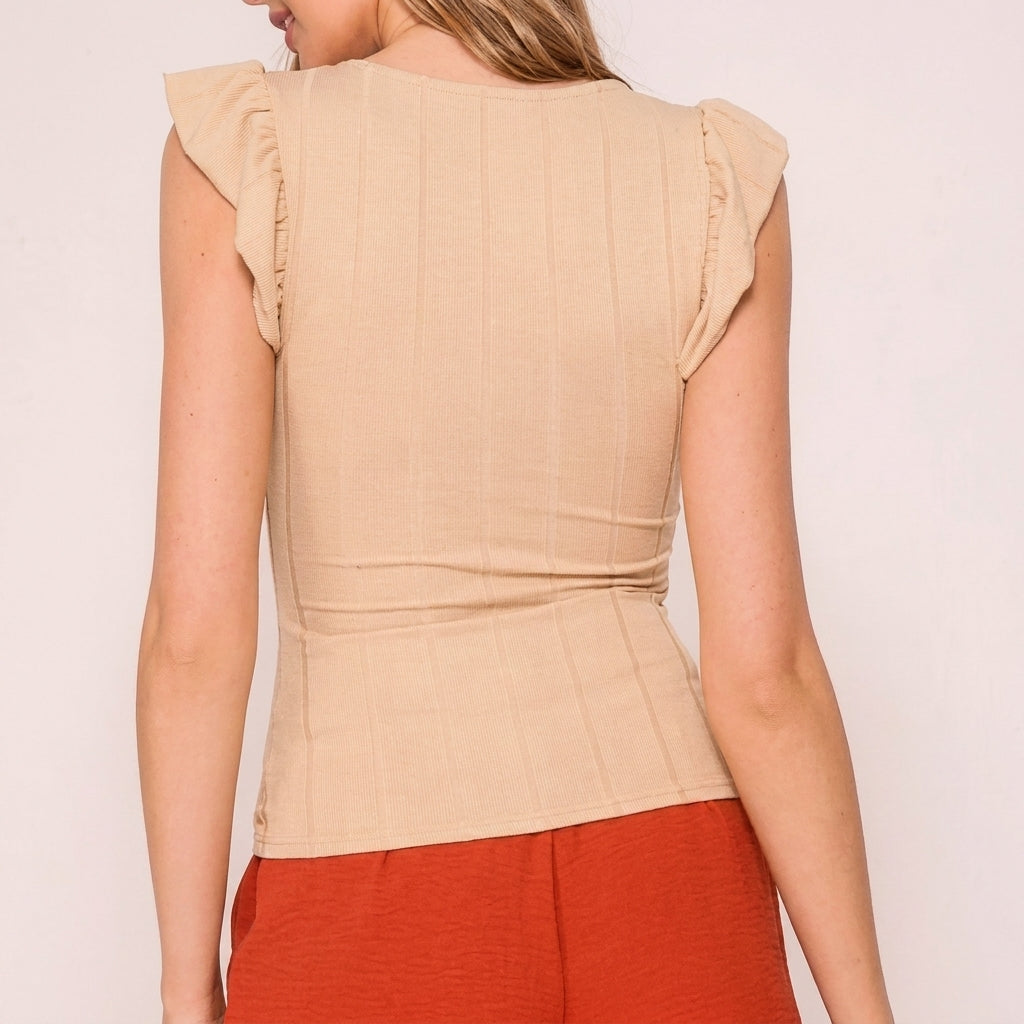 A woman in a beige top and burnt orange pants, viewed from the back.