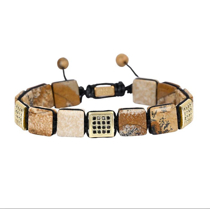 Square stone bracelet with adjustable cord and patterned accents.