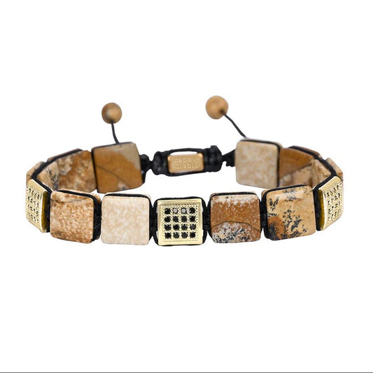Square stone bracelet with adjustable cord and patterned accents.