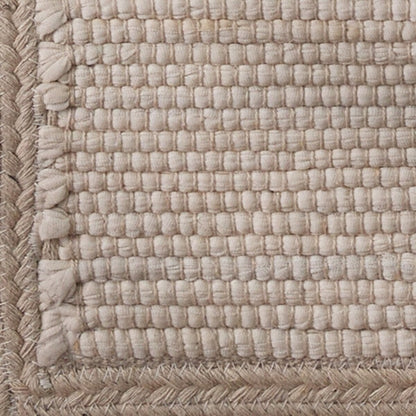 Close-up of woven beige fabric with textured edges.