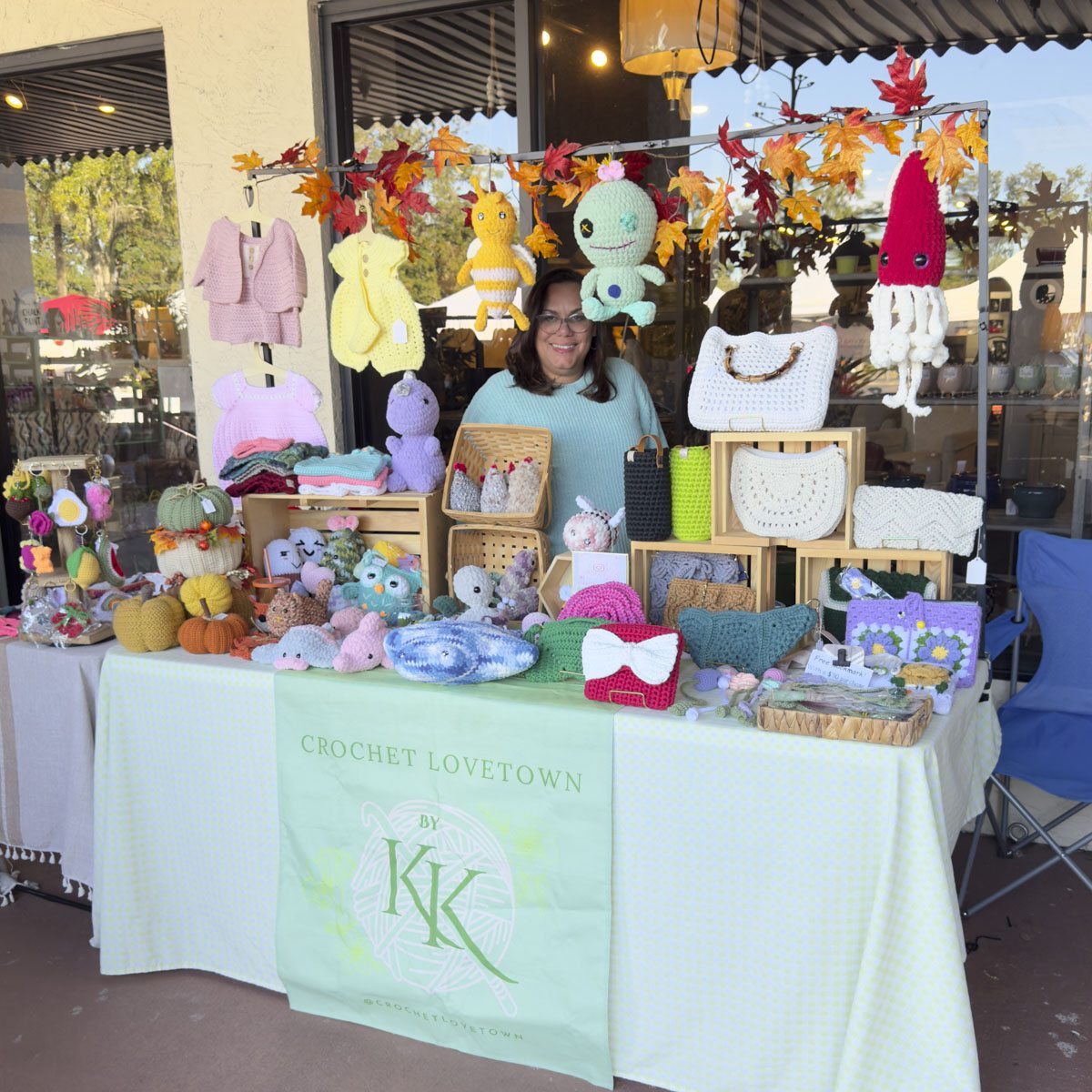 A vendor's table of handmade crochet animals and plush toys at the outdoor market