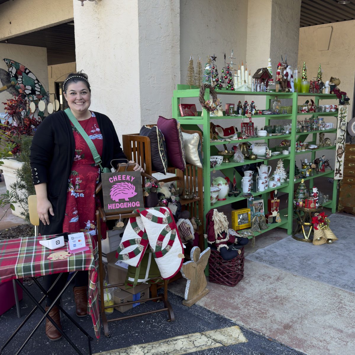 A vendor beside shelves of holiday decor and handmade pieces