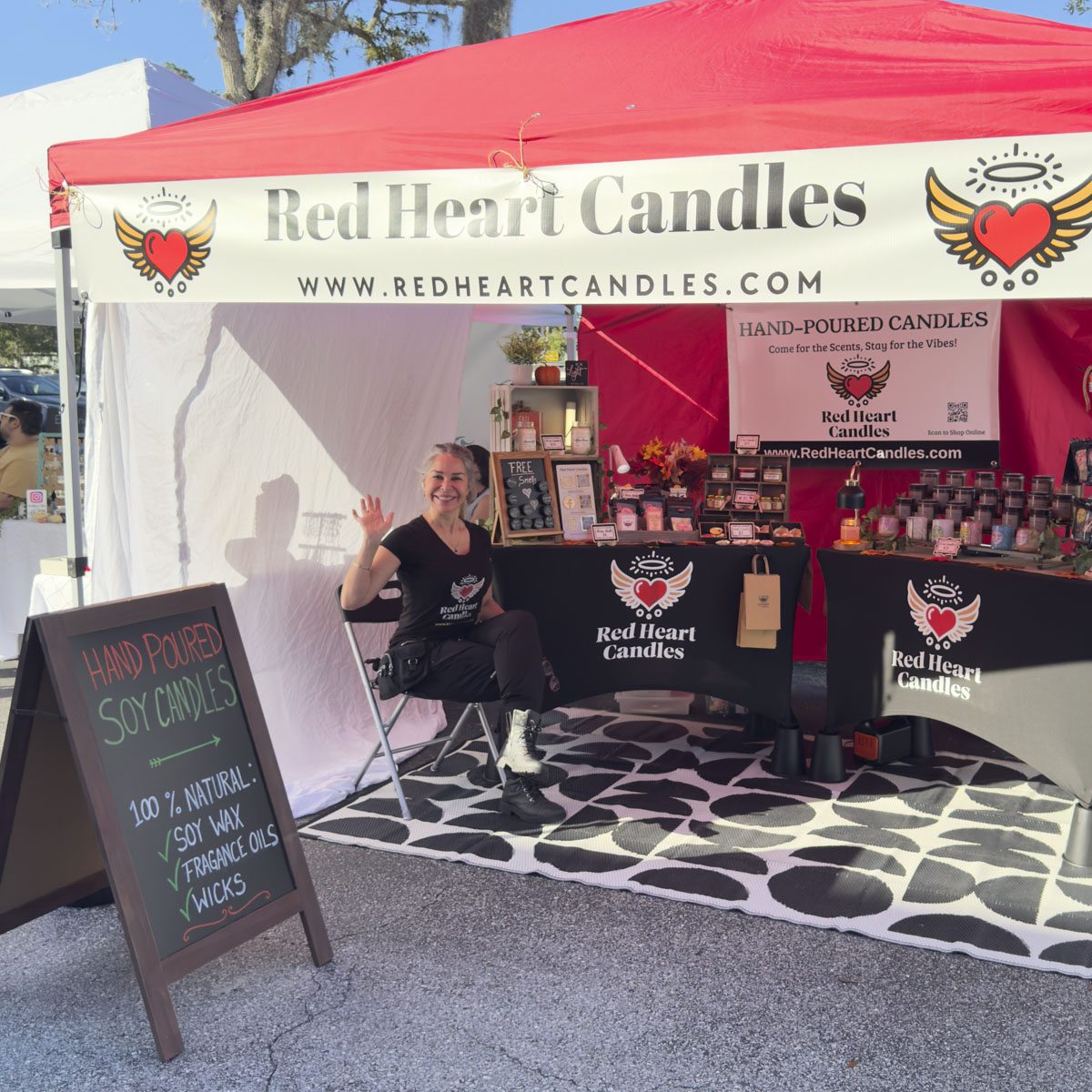 A 10 by 10 tent booth with candles and a chalkboard sign